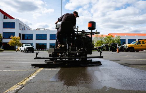 Worker on sealcoating machine